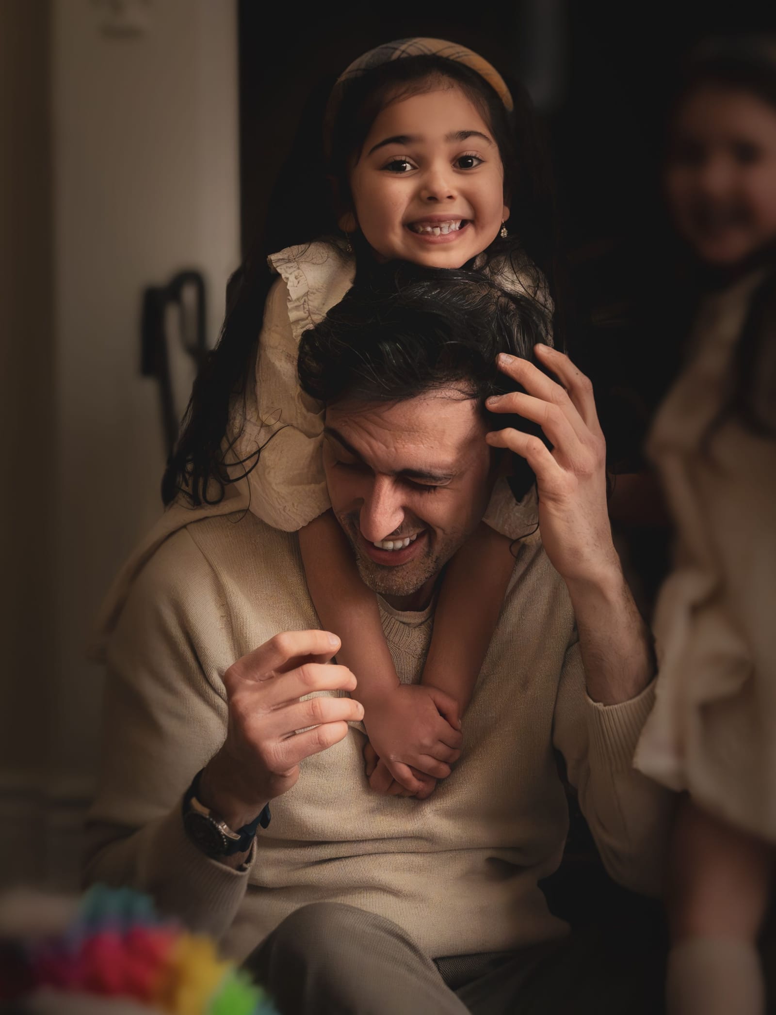 Father and child laughing together in warm window light, in-home family session, Arizona