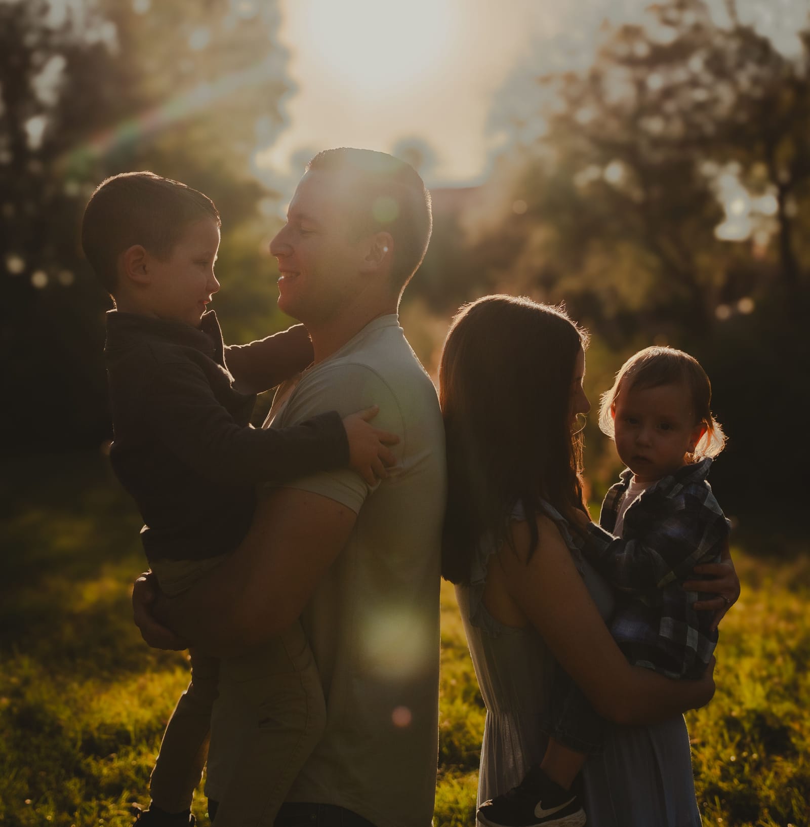 Family laughing together while peeking through a doorway, in-home session, Phoenix, Arizona