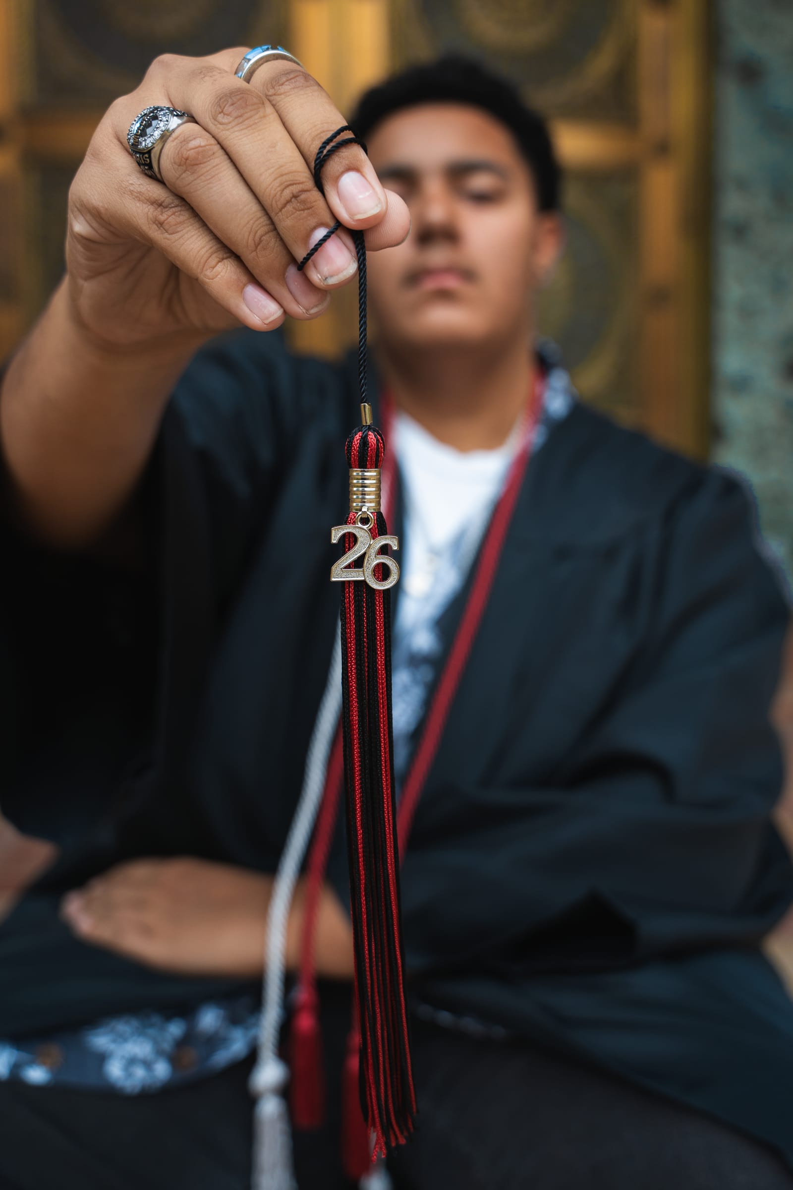 Senior holding a 2026 tassel charm toward the camera in downtown Phoenix, Arizona