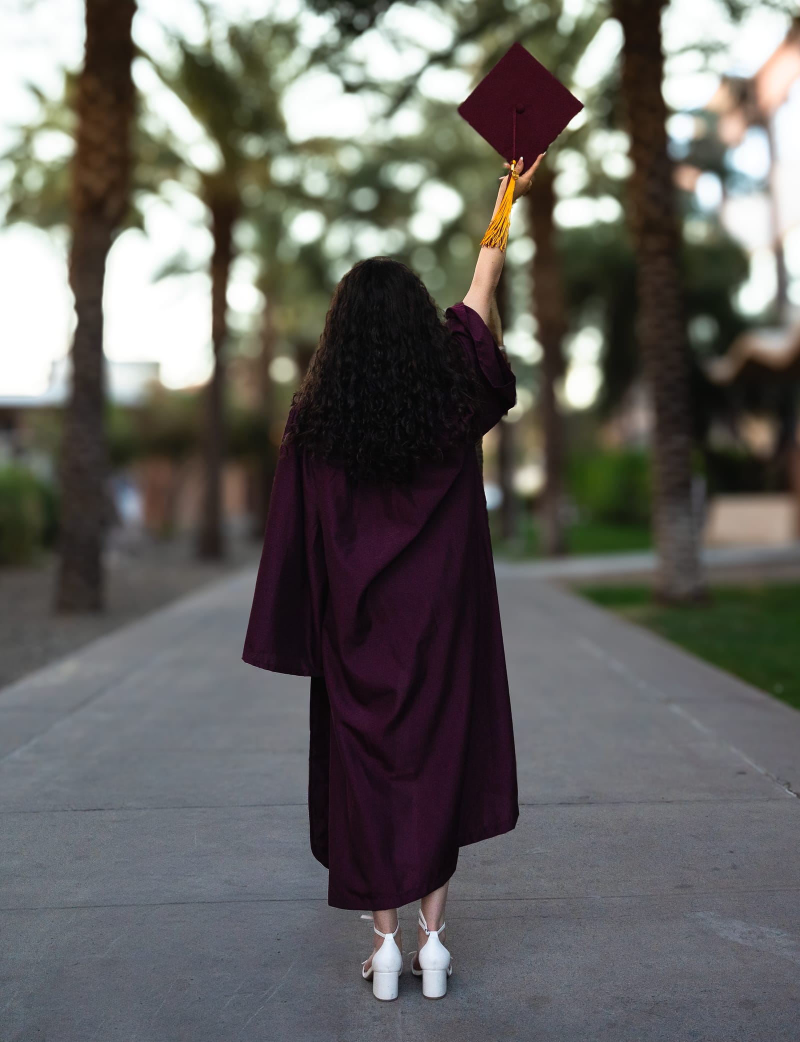 ASU graduate in yellow dress dancing on Palm Walk at golden hour, Tempe, Arizona